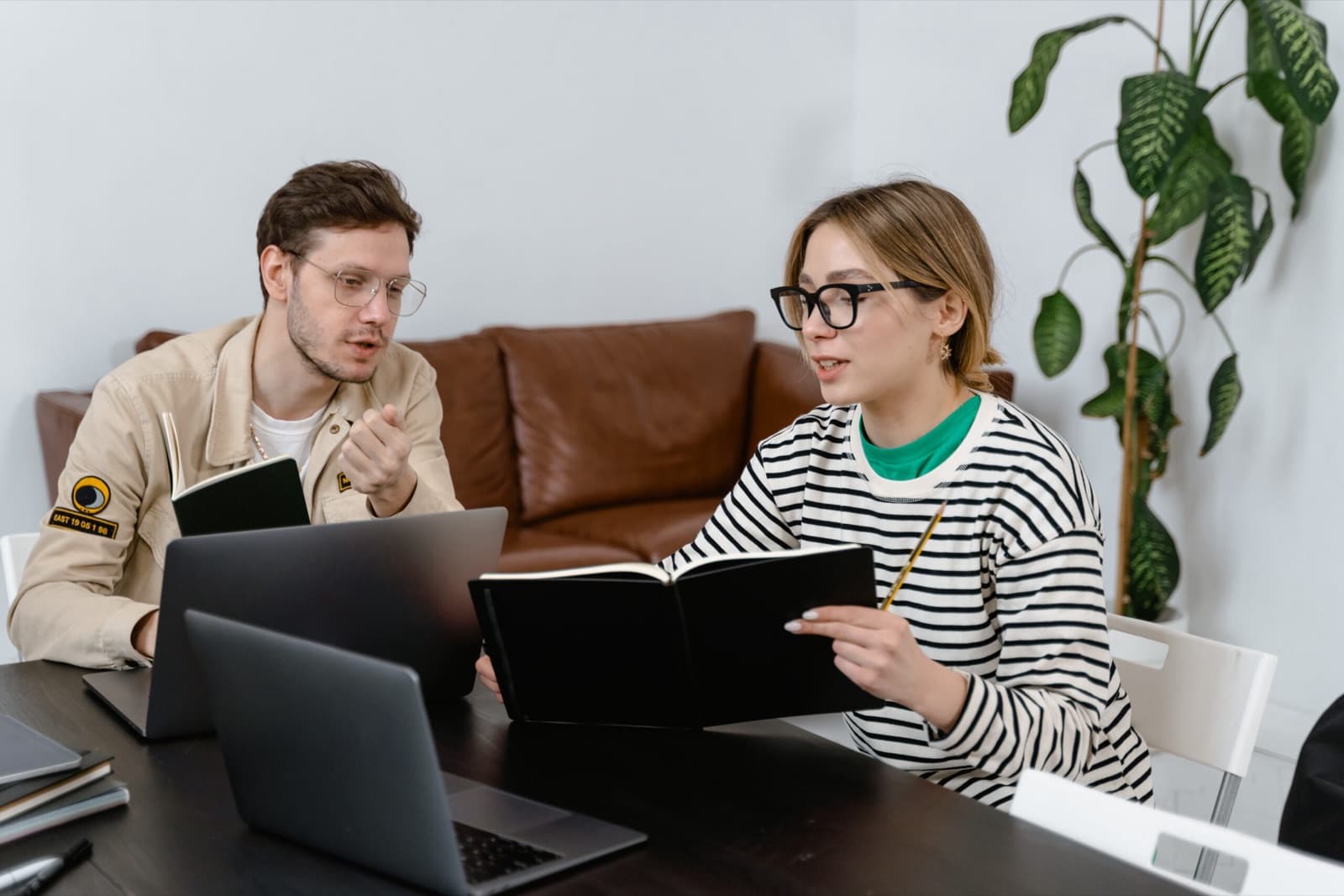 Zwei Studierende lernen gemeinsam mit Laptop und Skript